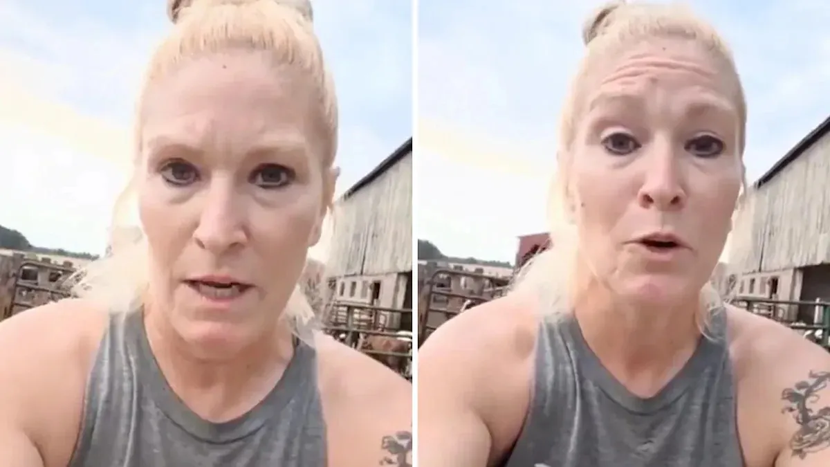 MAGA dairy farm owner speaks with a concerned expression in front of barns.